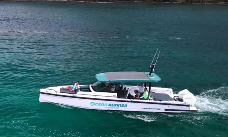 Book one of three powerboat charter option on the 37' Axopar during your St. Thomas vacatin. Pictured here is the Axopar powering through the crystal clear Caribbean Water with a mother and child at the front and a father and the captain in the back.