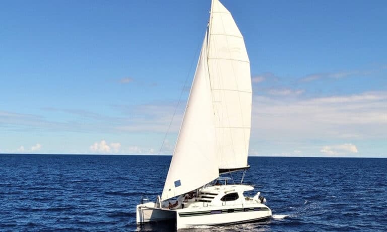 Book one of four sailing charter options from Kindred during your St. Thomas vacation. Pictured here is a catamaran under full sail on the deep blue water of the Caribbean.